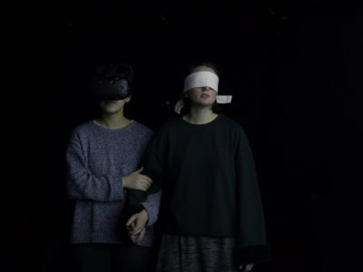 Une personne portant le casque VR, l'autre les yeux bandés