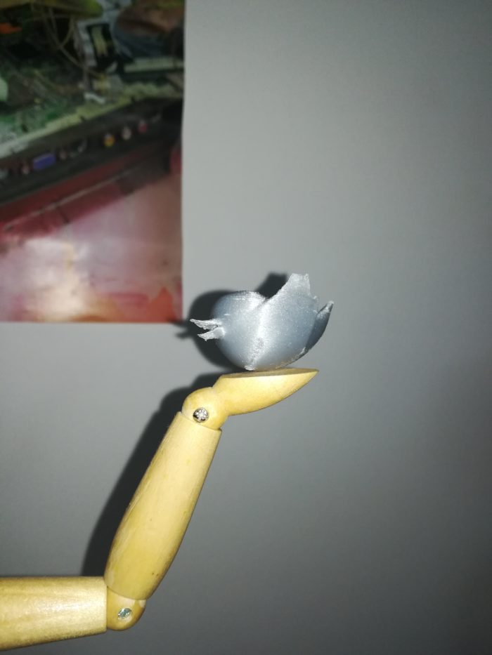 L'oiseau de Twitter imprimé en 3D posé sur la main d'une marionette