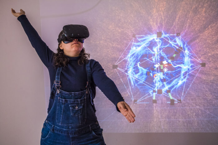 Ariane fait un mouvement des bras avec le casque de réalité virtuelle